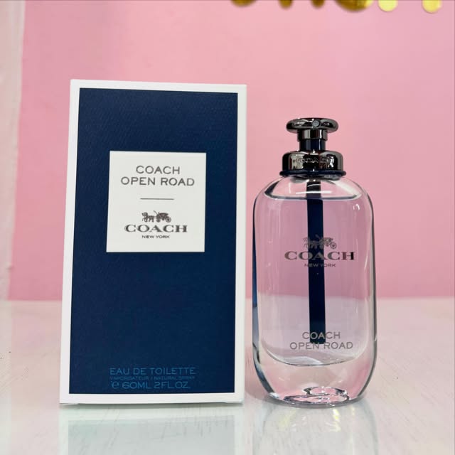 Perfume Coach Open Road junto a su caja azul.